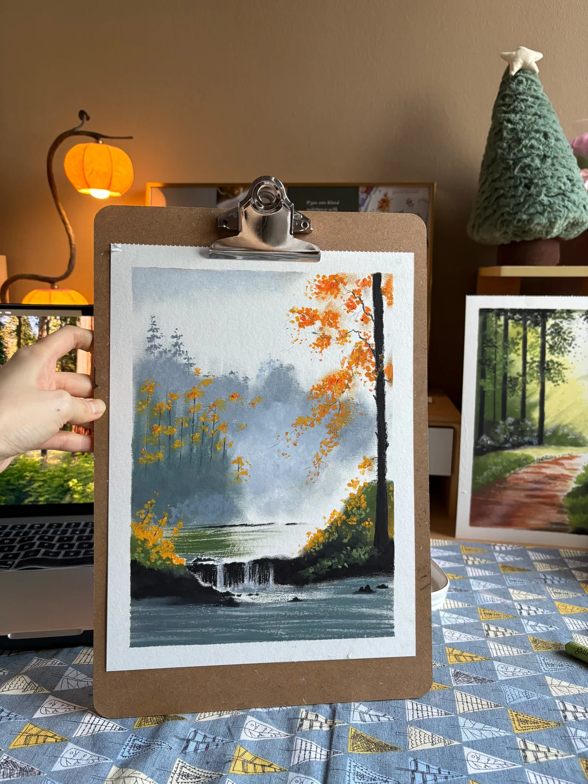 Painting of a small waterfall and still water surrounded by misty trees and autumn foliage.